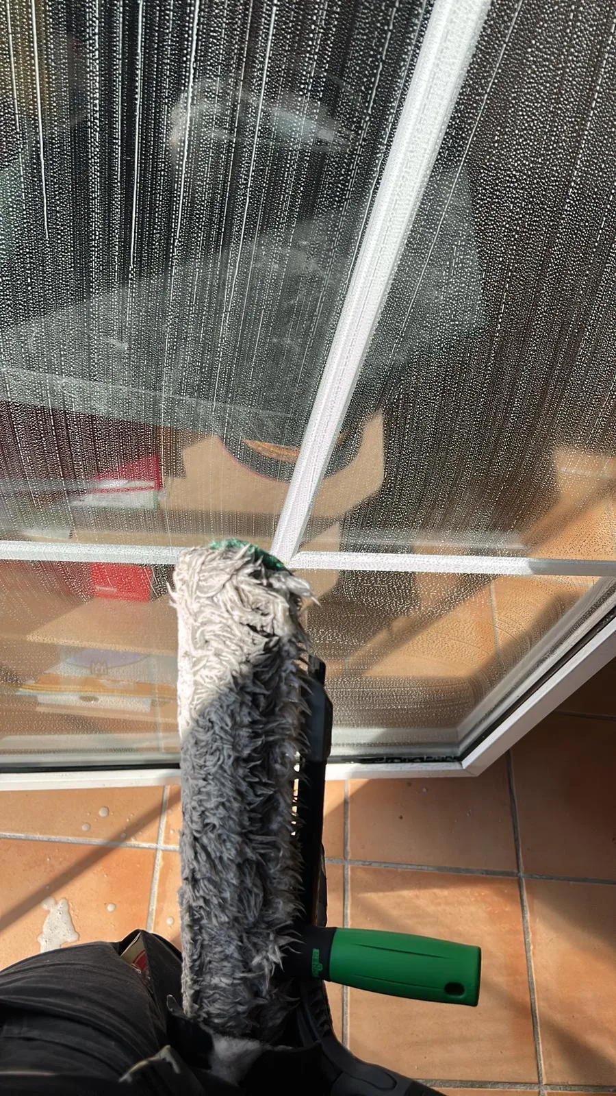 Fensterreinigung mit Einwascher auf einer Glasfläche
