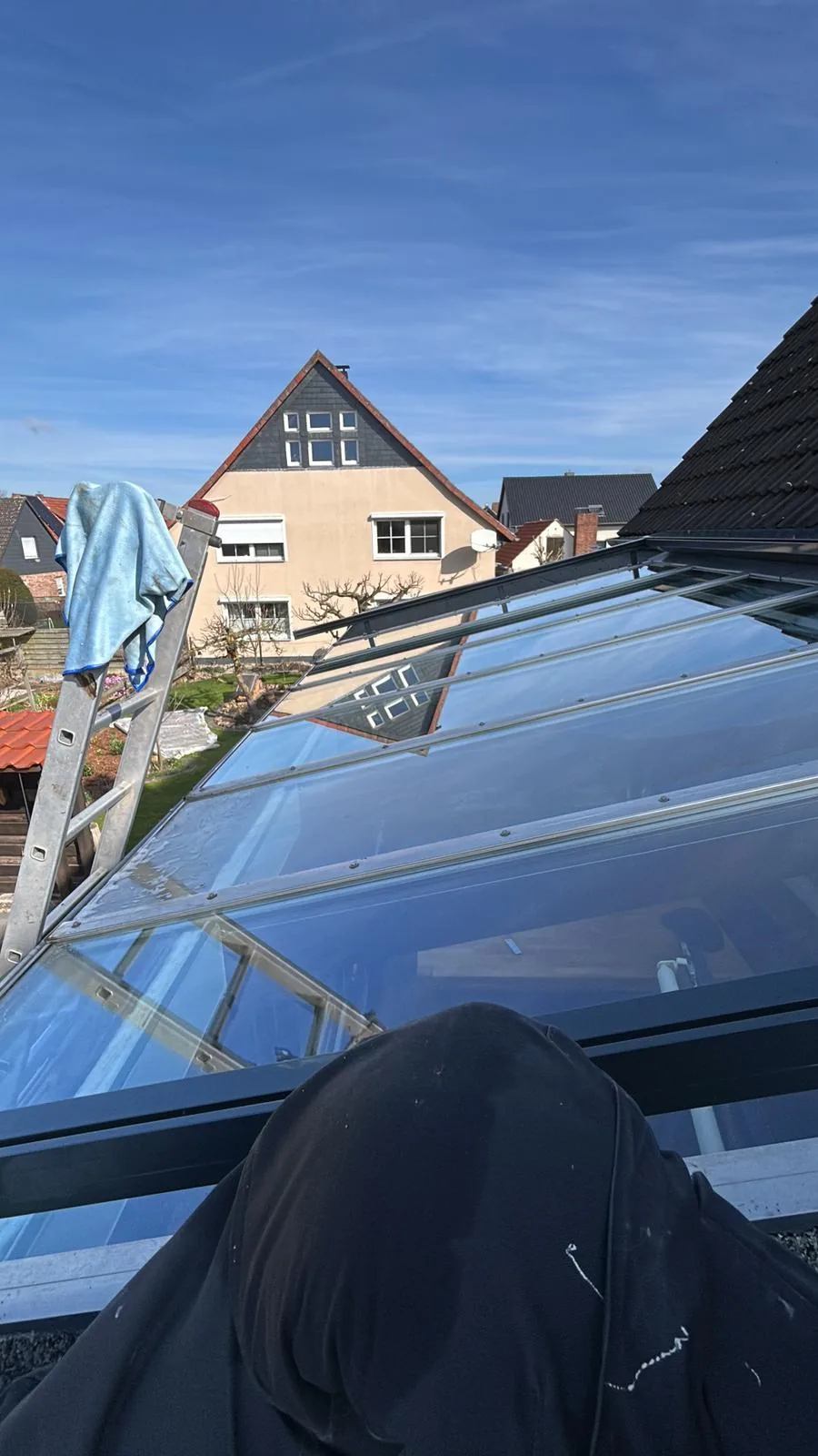 Reinigung eines Wintergartendachs mit Leiter